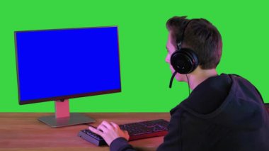 Kulaklıklı heyecanlı oyuncu Yeşil Ekrandaki Kameraya gülümsüyor, Chroma Key.