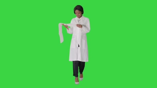 Lächelnde afrikanisch-amerikanische Ärztin liest Kardiogramm auf einem Green Screen, Chroma Key. — Stockvideo