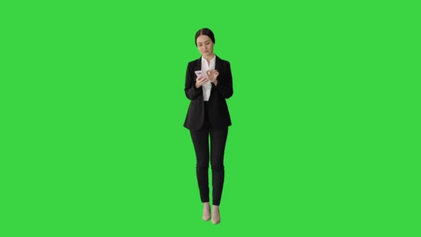 Takım elbiseli sıradan bir kadın telefonuyla yeşil ekranda mesaj atıyor, Chroma Key.. — Stok video