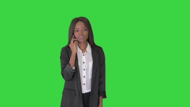 Случайная афро-американская предпринимательница разговаривает по телефону во время прогулки по зеленому экрану, Chroma Key. — стоковое видео