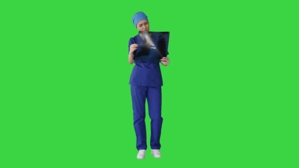 Tänker kvinnlig läkare i uniform undersöka en lungröntgen på en grön skärm, Chroma Key. — Stockvideo