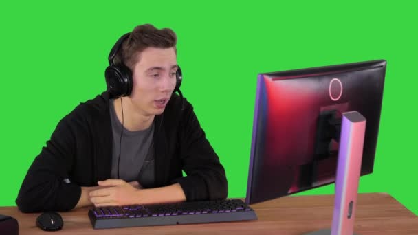 Jeune homme gamer ayant un appel vidéo sur PC sur un écran vert, Chroma Key. — Video