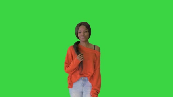 Sorridente donna afroamericana vestita con maglione luminoso e jeans posa con le mani in tasca su uno schermo verde, Chroma Key. — Video Stock