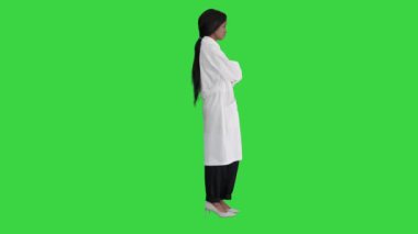 Ciddi bir Afro-Amerikan kadın doktor Yeşil Ekran, Chroma Key 'de ellerini çapraz olarak duruyor..