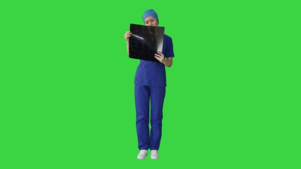 Médico femenino serio que mira la resonancia magnética del cerebro en una pantalla verde, Chroma Key. — Vídeos de Stock