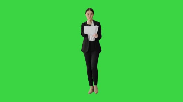 Серьёзная предпринимательница читает доклад, готовясь к презентации во время прогулки по зеленому экрану, Chroma Key. — стоковое видео