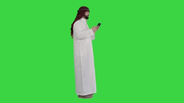 Homem árabe usando seu smartphone navegando na internet ou mensagens em uma tela verde, Chroma Key. — Vídeo de Stock