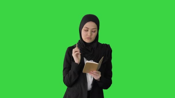 Muselman Affärskvinna tänkande och skriva idéer i hennes anteckningsblock när du går på en grön skärm, Chroma Key. — Stockvideo