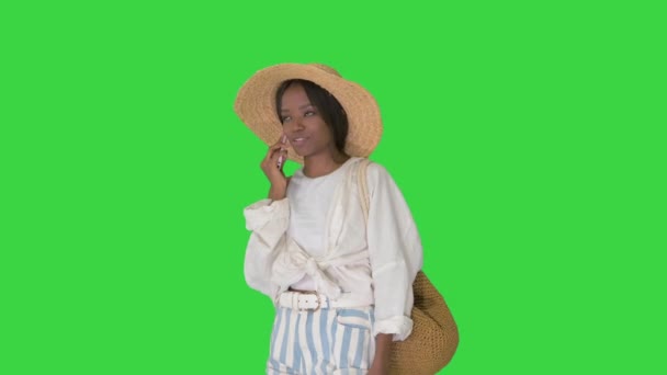 Mujer afroamericana bastante joven en un sombrero de paja hablando en su teléfono en una pantalla verde, Chroma Key. — Vídeos de Stock