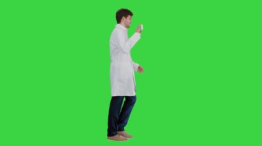 Steteskoplu gülümseyen erkek doktor yeşil ekranda, Chroma Key reklamları yapıyor..