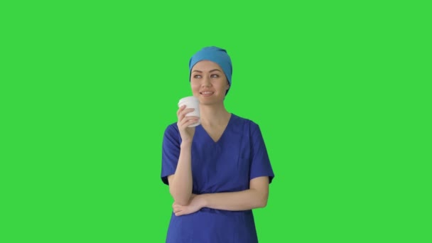 Gülümseyen kadın doktor ya da mavi üniformalı hemşire yeşil ekranda kahve molası veriyor, Chroma Key. — Stok video