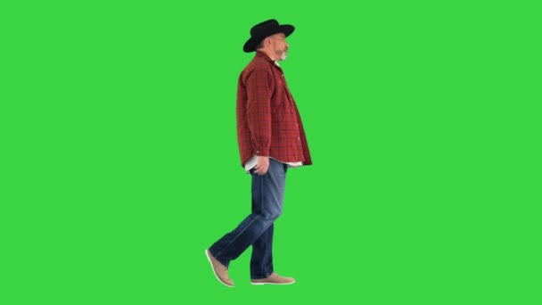 Yeşil ekranda yürüyen şapkalı kıdemli çiftçi, Chroma Key. — Stok video