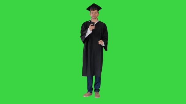 Diplomás diák sms üzenetet a telefonon egy zöld képernyőn, Chroma Key. — Stock videók