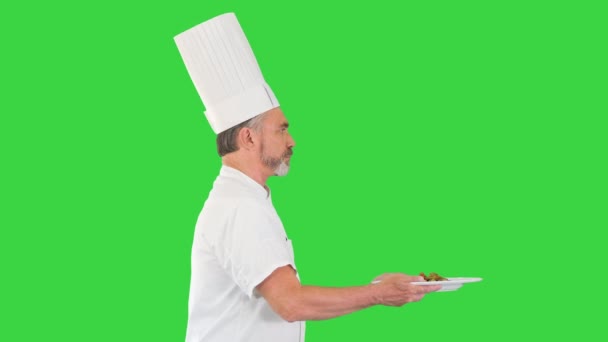 Мужчина в белой униформе шеф-повара бегает с тарелкой салата на зеленом экране, Chroma Key. — стоковое видео