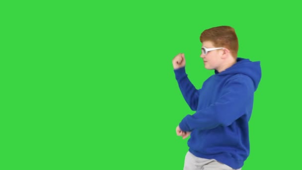 緑の画面、クロマキーを歩いている間にクールな男の子のダンス. — ストック動画
