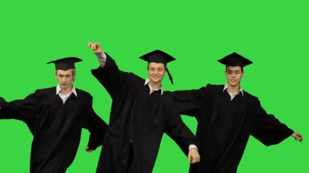 Trzech absolwentów w szatach i moździerzach tańczących synchronicznie na zielonym ekranie, Chroma Key. — Wideo stockowe