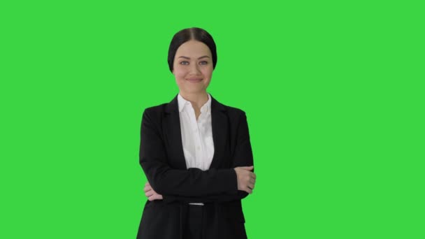 Självsäker ung affärskvinna poserar med korsade armar på en grön skärm, Chroma Key. — Stockvideo