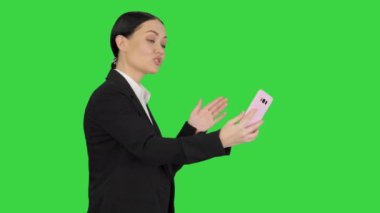 Takım elbiseli genç bir kadın telefonunda iş videosu var. Yeşil Ekran, Chroma Key..
