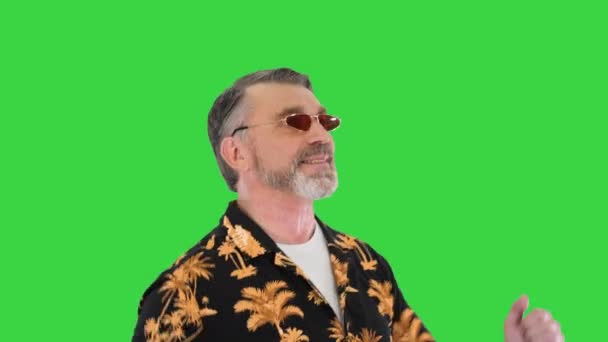 Δροσερός παππούς με γυαλιά ηλίου χορεύει με αστείο τρόπο σε μια πράσινη οθόνη, Chroma Key. — Αρχείο Βίντεο