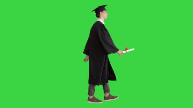 Yüksek lisans öğrencisi yeşil ekranda yürüyor ve gülümsüyor, Chroma Key.