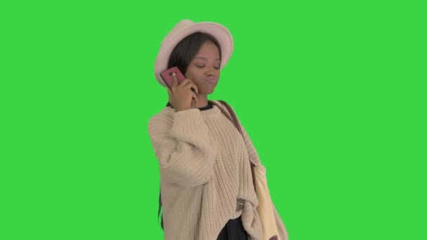 Mujer afroamericana bonita en suéter de punto y sombrero blanco contestando su teléfono en una pantalla verde, Chroma Key. — Vídeos de Stock