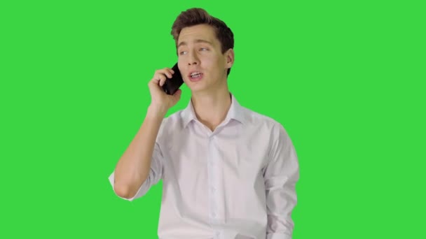 Schöner Mann, der telefoniert, während er auf einem grünen Bildschirm läuft, Chroma Key. — Stockvideo
