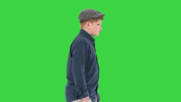 緑の画面、クロマキーの上を歩くポケットに手でスタイリッシュな十代の男の子. — ストック動画