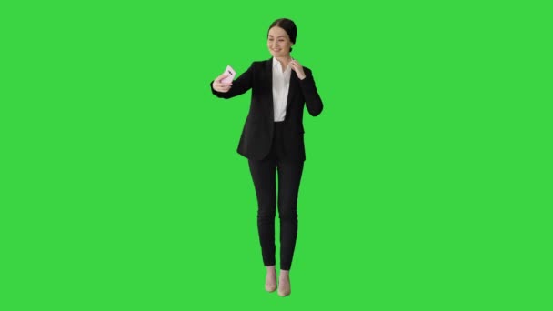 笑顔のビジネスマンの女性は、緑の画面、クロマキーに彼女の携帯電話で自撮り. — ストック動画