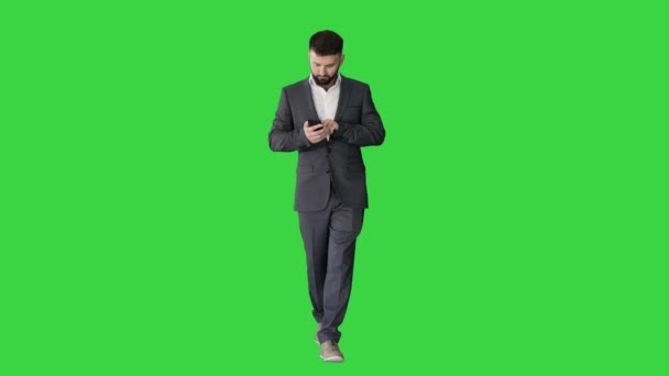 Podnikatel kráčí a používá telefon na zelené obrazovce, Chroma Key. — Stock video