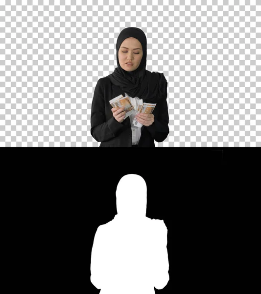 Krásná žena v hidžábu chůze a počítání peněz, Alpha Channel — Stock fotografie