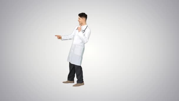 Junger Arzt im Laborkittel tanzt auf Gradienten-Hintergrund. — Stockvideo