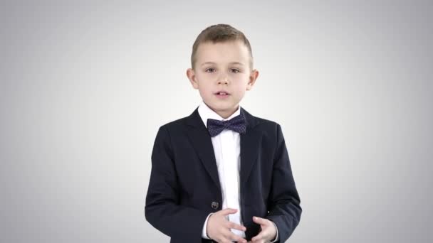 Serious little boy giving a speech to camera on gradient background. — Stock Video