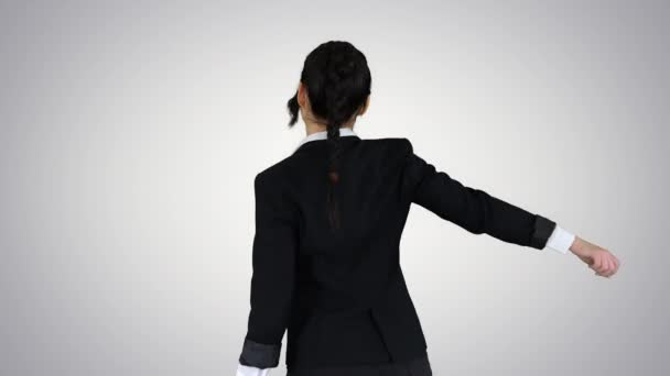 グラデーションの背景で踊る自信に満ちた若いビジネスマンの女性. — ストック動画