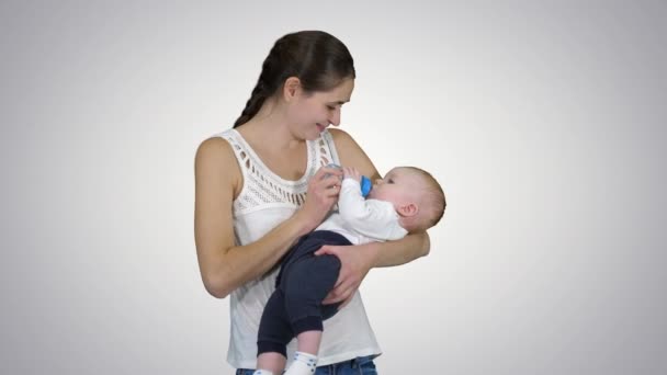 Madre da a bebé a beber de biberón, canal alfa — Vídeos de Stock
