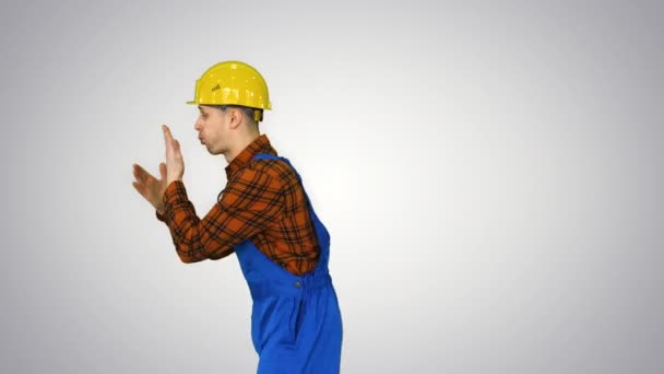 Operaio edile disposto a lavorare, pronto a lavorare Batte le mani e fa capovolgere fresco poi sorride alla fotocamera su sfondo sfumato. — Video Stock