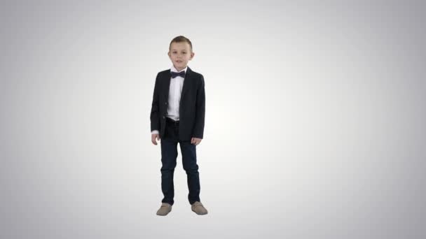穿着西服的男孩在渐变的背景下走来走去问候你. — 图库视频影像