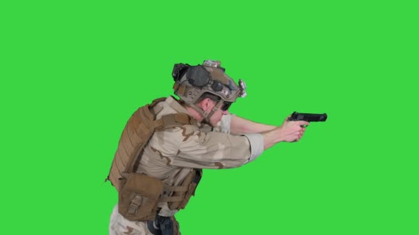 Soldato moderno, combattente della squadra antiterrorismo che mira e spara con la pistola su uno schermo verde, chiave cromatica. — Video Stock