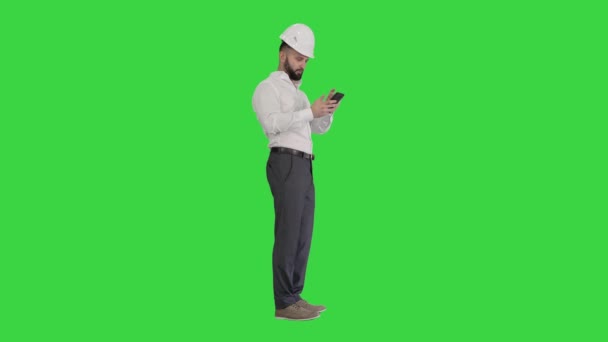Smart engineer in wit shirt en veiligheid engineering hoed met behulp van smartphone op een groen scherm, Chroma Key. — Stockvideo