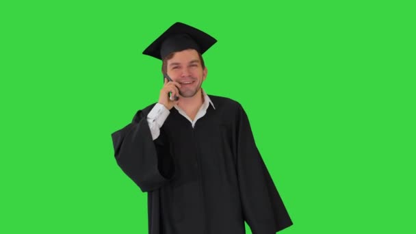 Hombre graduado en vestido y mortero hablando por teléfono mientras camina con su diploma en una pantalla verde, Chroma Key. — Vídeos de Stock