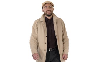 Ceketli gülümseyen adam kameraya bakıyor ve beyaz arka planda yürüyor..