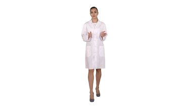 Beyaz arka planda yürürken kameraya açıklama yapan ve konuşan kadın doktor..
