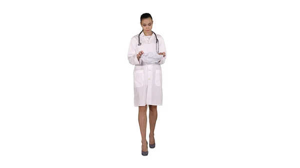 Arzt mit Stethoskop setzt Arzthut oder Mütze auf weißem Hintergrund auf. — Stockfoto