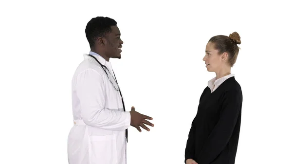 Erkek Afrikalı doktor beyaz arka planda kadın hastayla konuşuyor.. — Stok fotoğraf