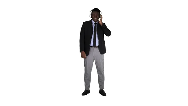 Knappe Afro-Amerikaanse zakenman in koptelefoon luistert naar muziek op witte achtergrond. — Stockfoto