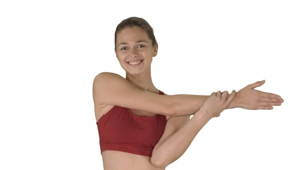 Hacer ejercicios de estiramiento Hermosa mujer joven haciendo ejercicios de estiramiento mientras camina sobre fondo blanco. —  Fotos de Stock