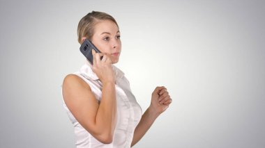 Çekici bir iş kadını, arka planda dururken cep telefonuyla arıyor..