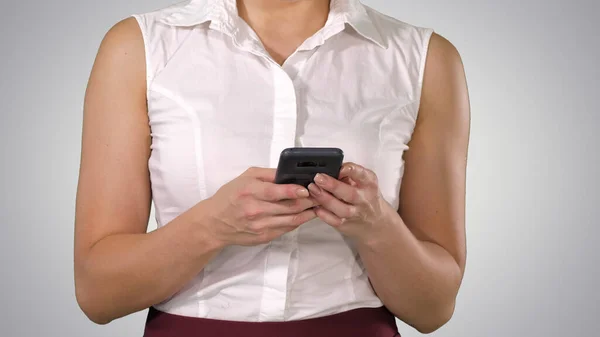 Mani delle donne che tengono il telefono cellulare su sfondo sfumato. — Foto Stock