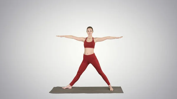 Perempuan berlatih yoga, berdiri dalam latihan Extended Side Angle, Utthita parsvakonasana berpose pada latar belakang gradien. — Stok Foto