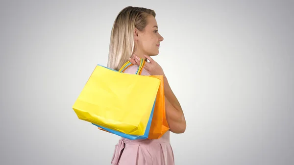 Vamos começar a venda de compras Mulher em rosa andando com sacos de compras no fundo gradiente. — Fotografia de Stock