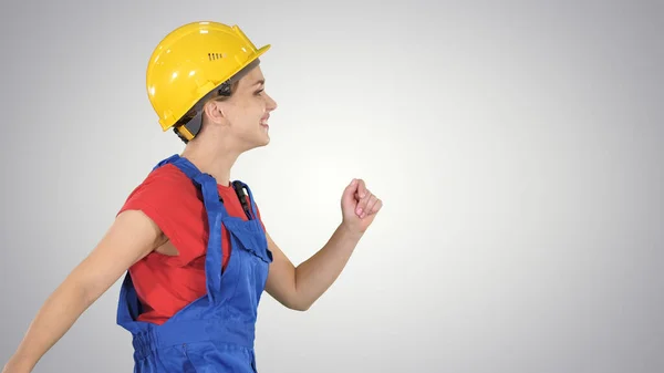 Vrouwelijke werknemer in hardhat wandelen gelukkig Bouw en architectuur concept op gradiënt achtergrond. — Stockfoto